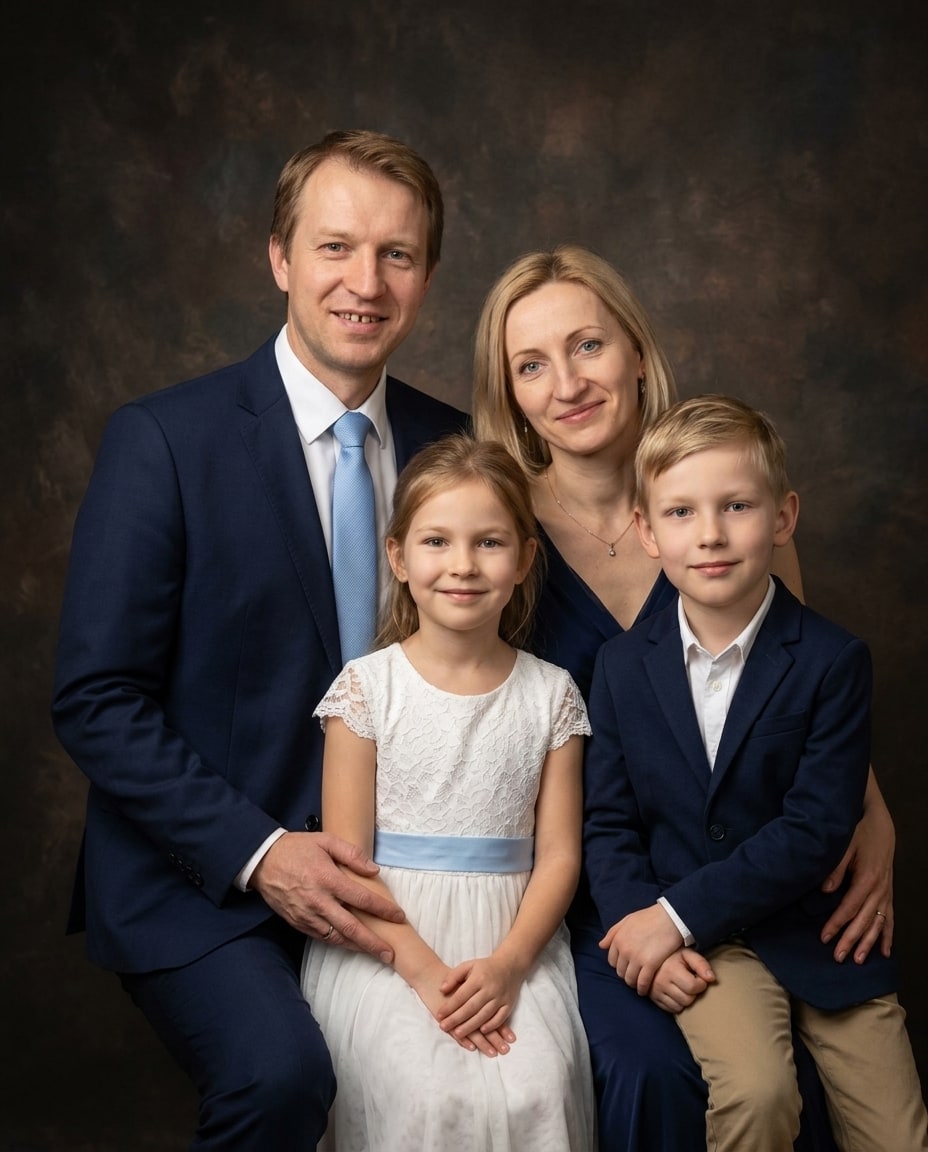 A smiling family of four in formal navy and white attire poses together against a dark brown mottled background.