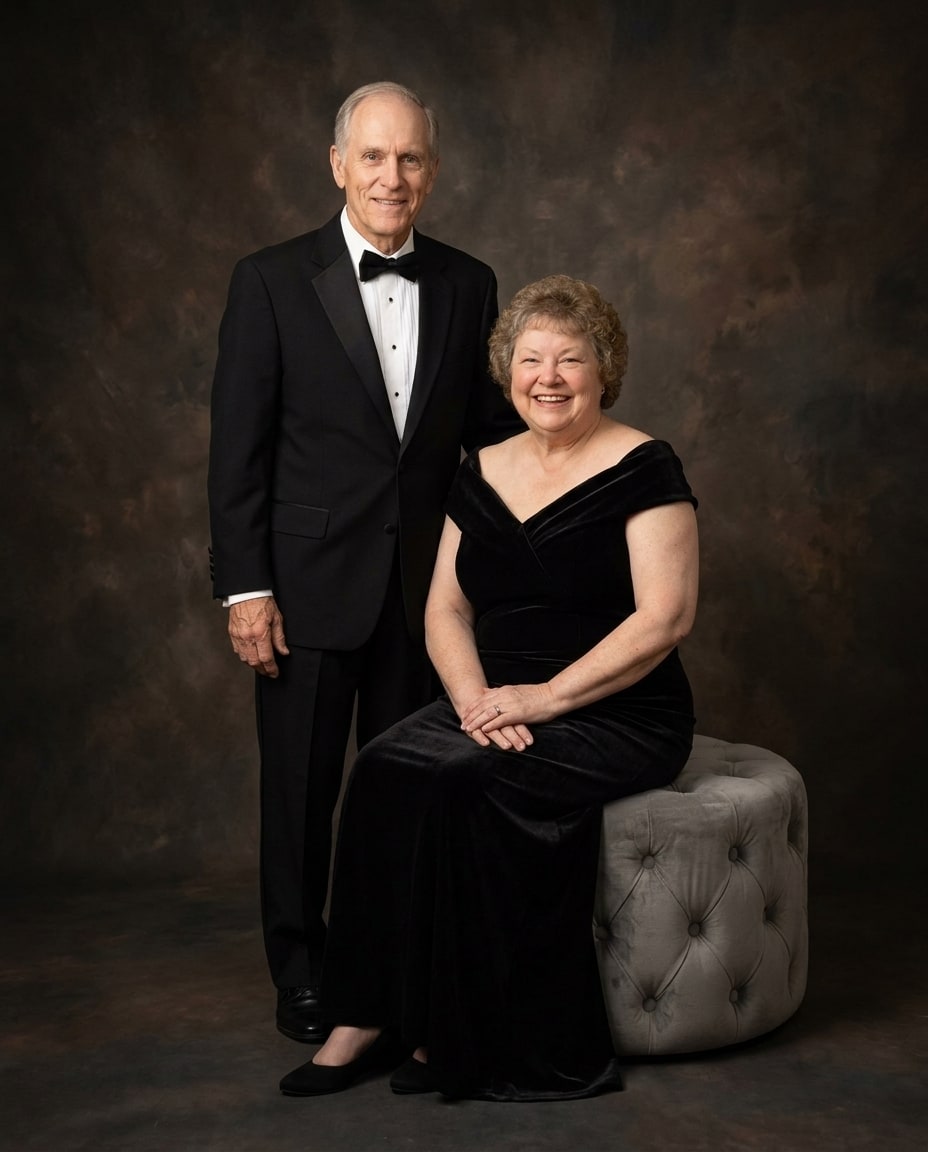 A parents memorial portrait on canvas featuring a smiling senior couple dressed in elegant black formal attire against a dark textured backdrop.